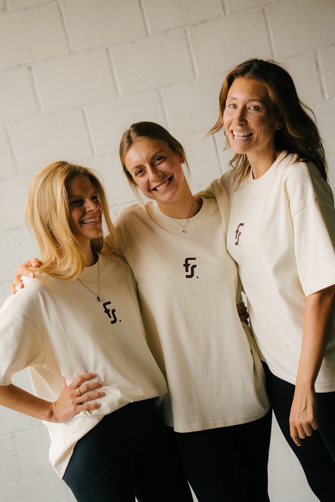 Drie leden arm in arm in hun Forme-shirt